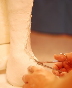 der Schutzstrumpf wird mit einer Schere aufgeschnitten